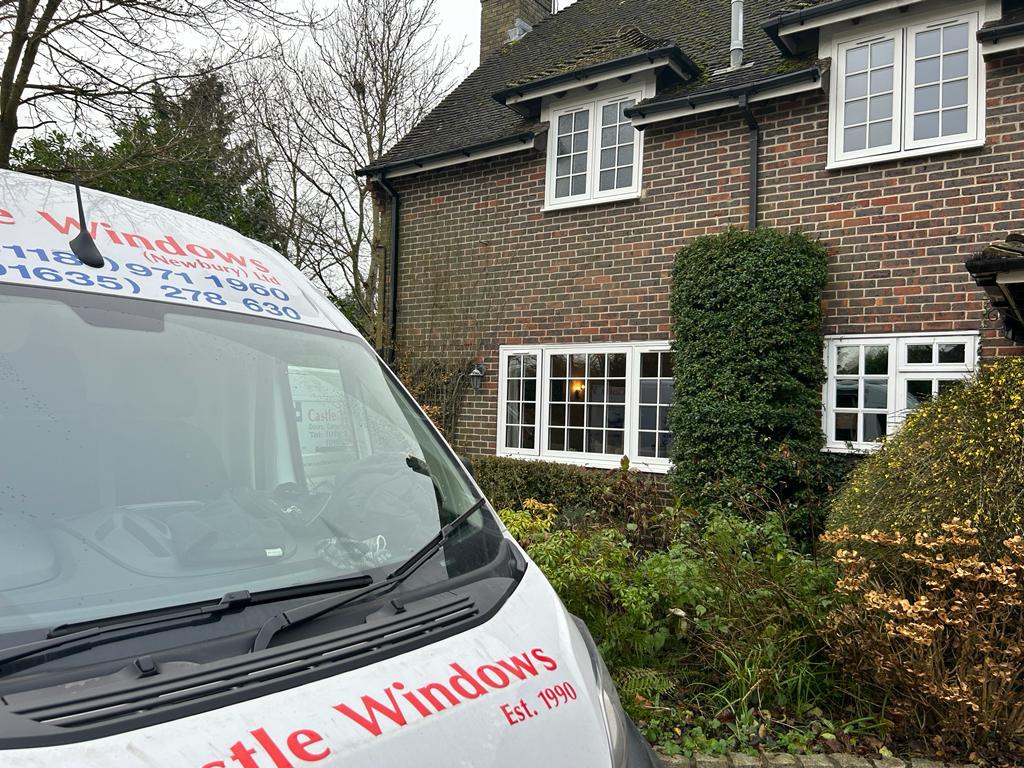 An external shot of a brick house with a branded van outside.